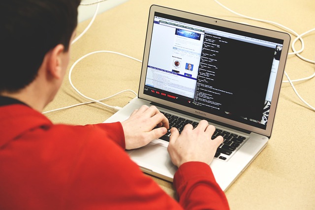 A person typing code on a laptop computer